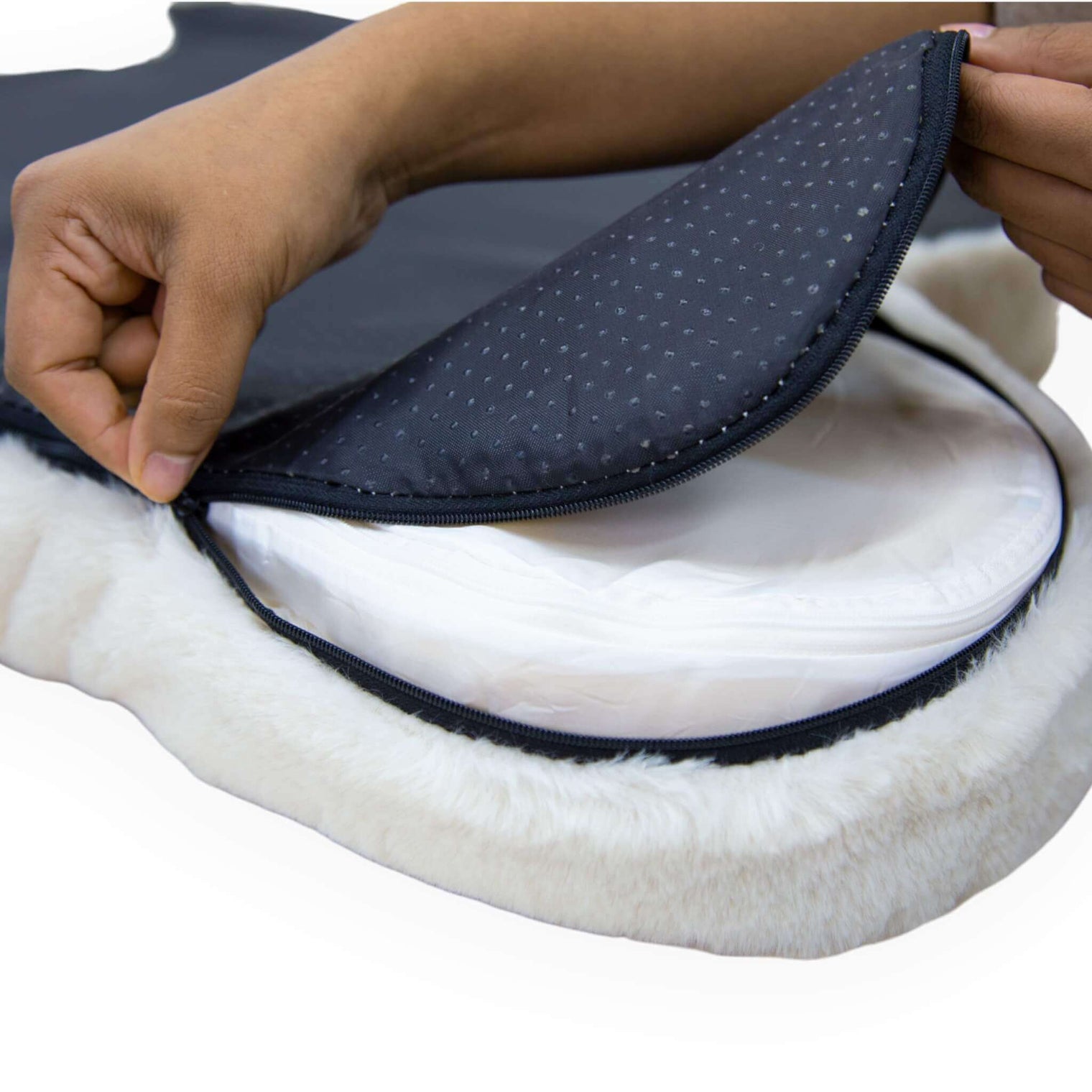 Someone unzipping the washable cover of Hide shaped pet bed