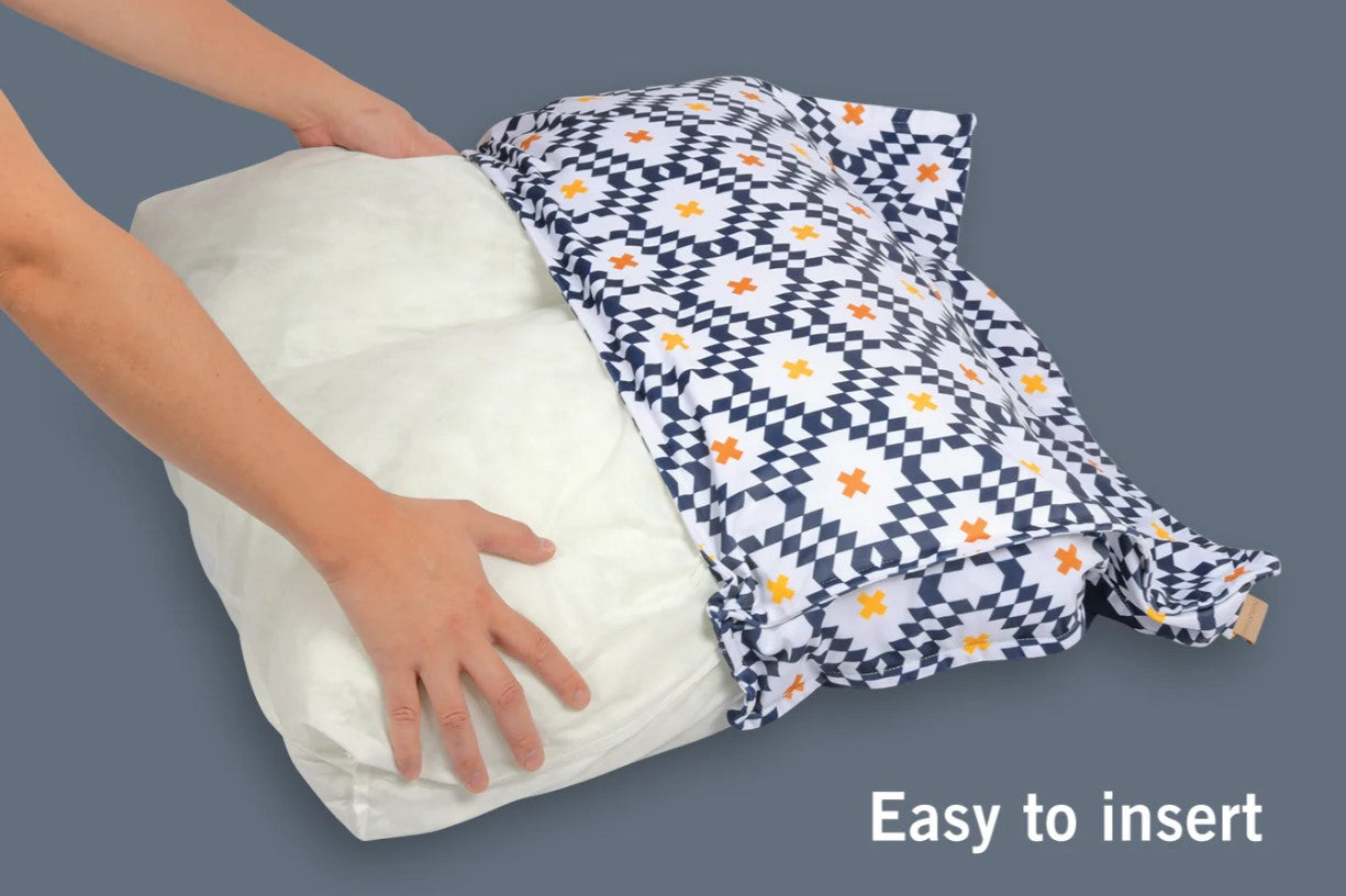 Person inserting filling into a patterned dog bed cover with the phrase 