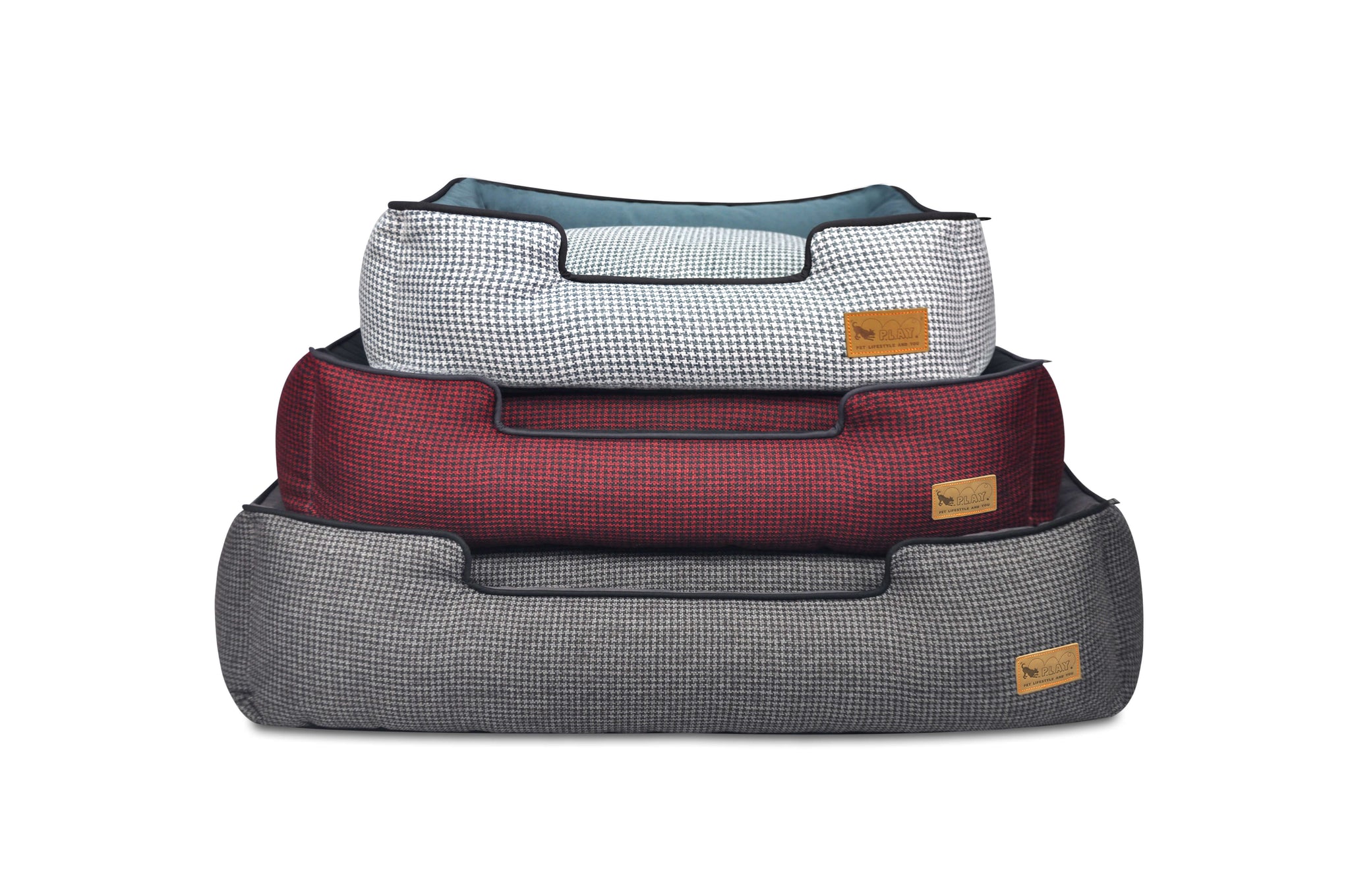 Three P.L.A.Y. Houndstooth Lounge Beds stacked in different chic colors for stylish pet relaxation and sophistication.