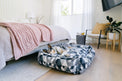 Dog lounging on P.L.A.Y. Mosaic Lounge Bed with colorful geometric pattern in a stylish bedroom