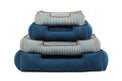 Stack of P.L.A.Y. Manhattan Lounge Beds in bolster style showcasing assorted sizes and blue tones for ultimate pet comfort.