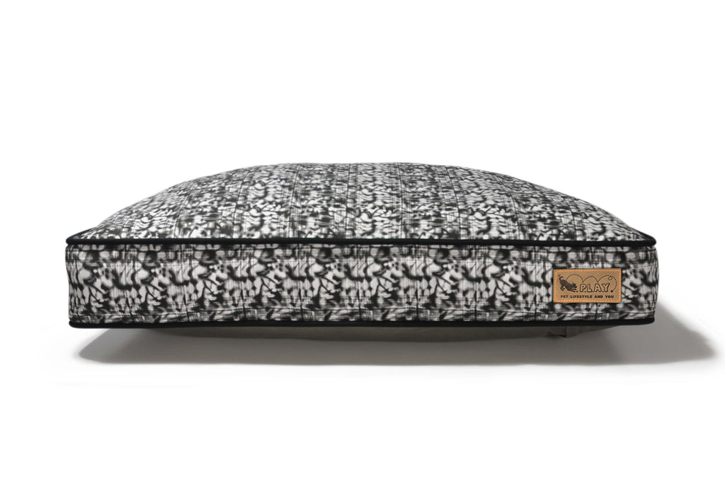 P.L.A.Y. Frolic Rectangle Bed with playful fabric, designed for dogs, featuring a vibrant black and white pattern and 100% natural cotton cover.