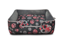 P.L.A.Y. Skulls & Roses Lounge Bed with skull and floral patterns, featuring raised sides for pet comfort and a reversible inner cushion.