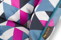 Close-up of colorful geometric pattern on P.L.A.Y. Mosaic Lounge Bed with bold pink, blue, and white shapes.
