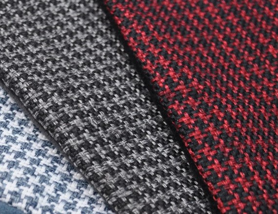 Three Houndstooth fabric colors for P.L.A.Y. Round Bed in close-up: blue, black, and red.